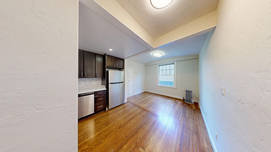 A kitchen with dark wood cabinets and a white wall.